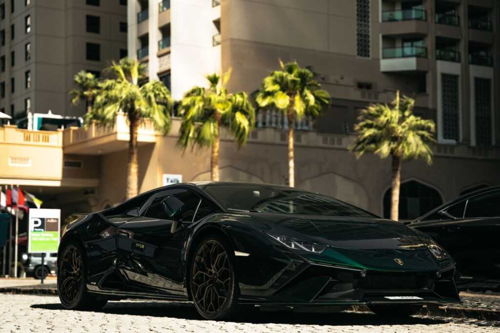 Sleek luxury sports car set against the backdrop of Dubai's modern architecture and palm trees.